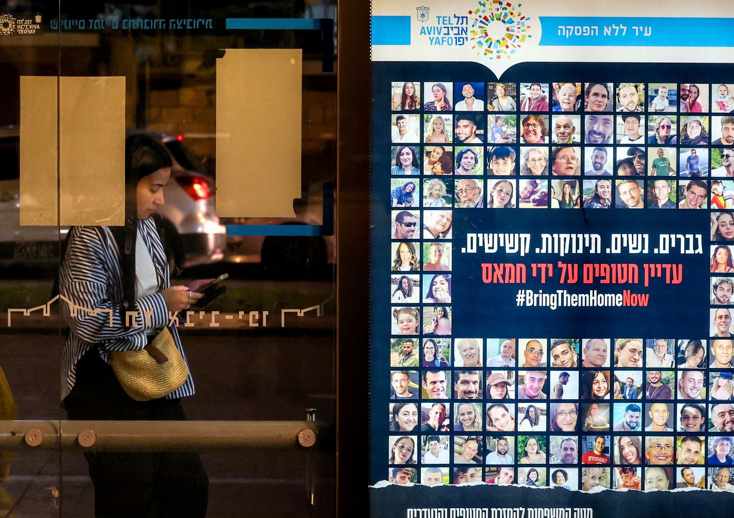 Un manifesto con le foto degli ostaggi israeliani a una fermata dell'autobus a Tel Aviv