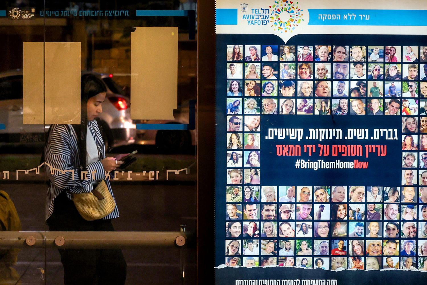 Un manifesto con le foto degli ostaggi israeliani a una fermata dell'autobus a Tel Aviv