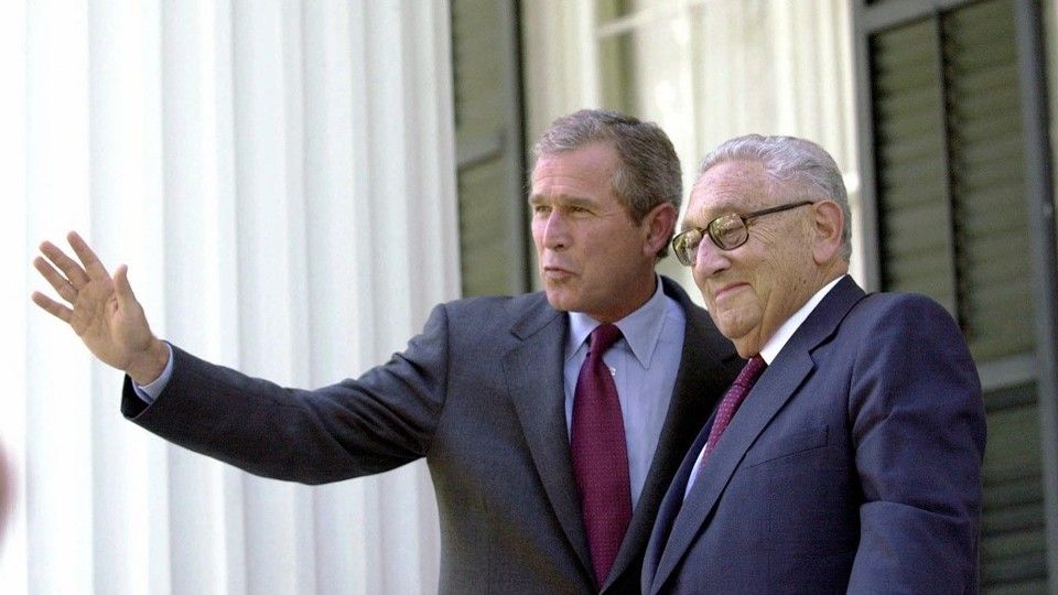 George W. Bush saluta i giornalisti accanto a Henry Kissinger&nbsp;