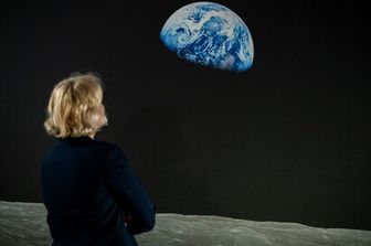 Una donna osserva l'iconica foto della Terra scattata nel 1968
