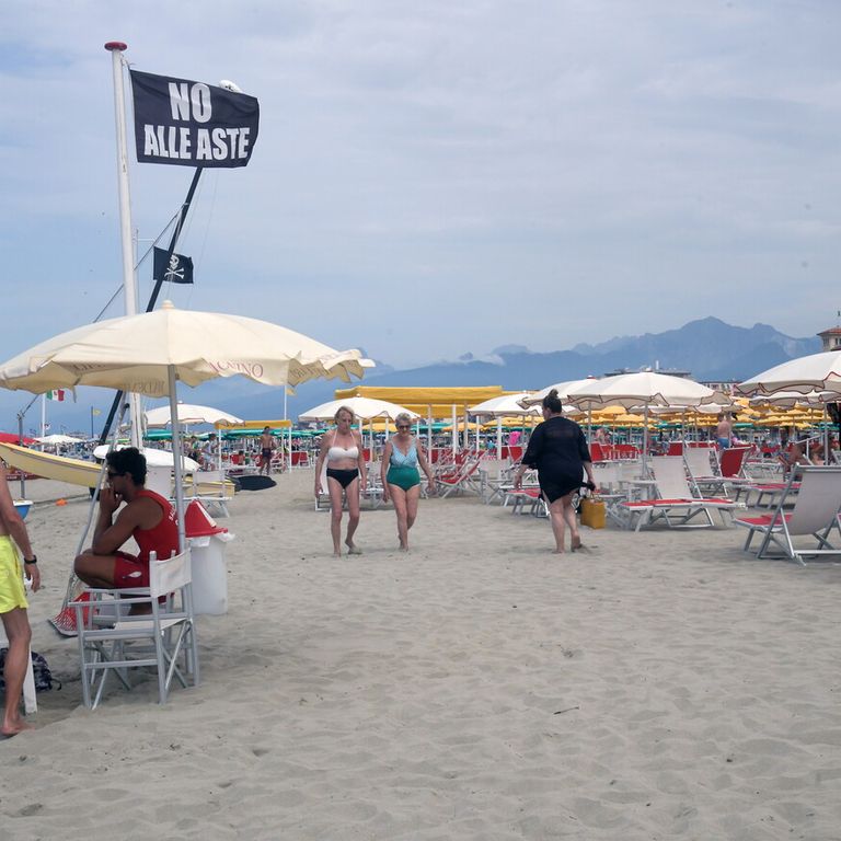 Una spiaggia con una bandiera che esprime la protesta dei balneari