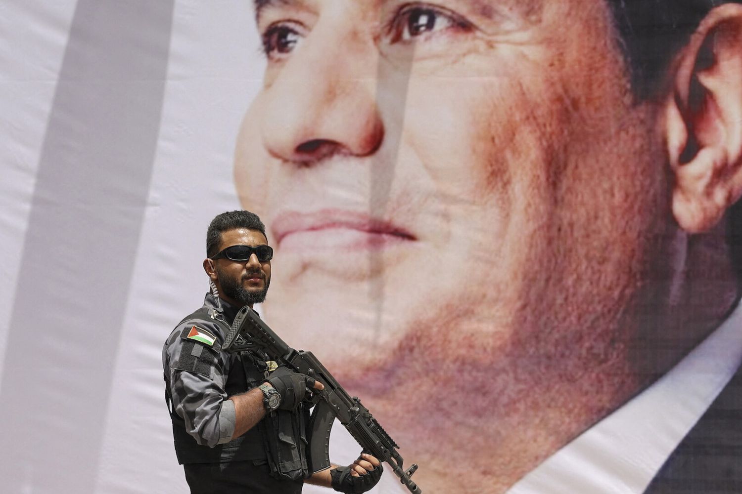 Un membro delle forze di sicurezza di Hamas di fronte a un ritratto di Al Sisi