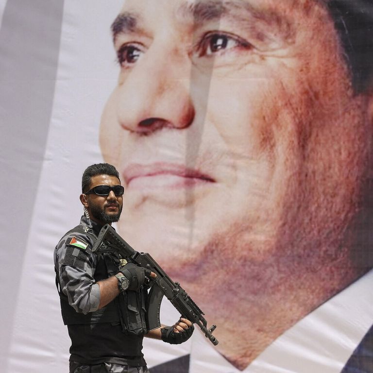 Un membro delle forze di sicurezza di Hamas di fronte a un ritratto di Al Sisi