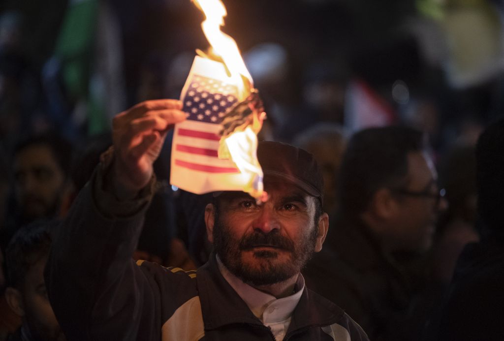 Manifestante iraniano brucia la bandiera Usa durante una protesta anti-statunitense davanti all'ambasciata britannica di Teheran