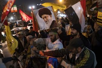 Iraniani, durante una protesta anti Usa-Gb, portano un ritratto della Guida Suprema iraniana, l'Ayatollah Ali Khamenei, e una bandiera yemenita mentre strappano una bandiera israeliana