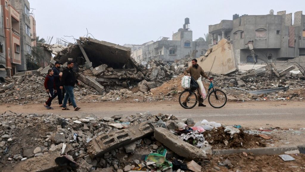 Uomini camminano lungo una strada devastata dai bombardamenti israeliani a Rafah, nel sud della Striscia di Gaza, il 9 febbraio 2024,