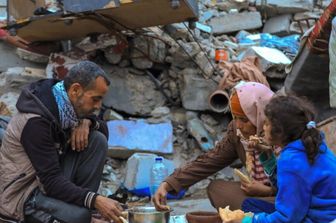 Sfollati da Gaza mangiano a Rafah tra le macerie