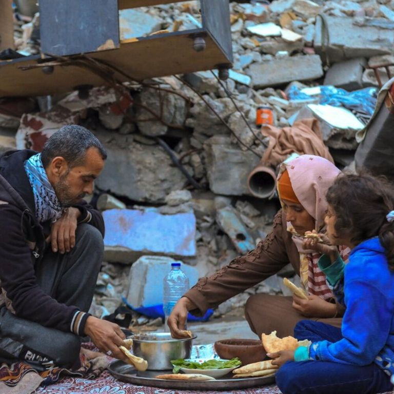 Sfollati da Gaza mangiano a Rafah tra le macerie