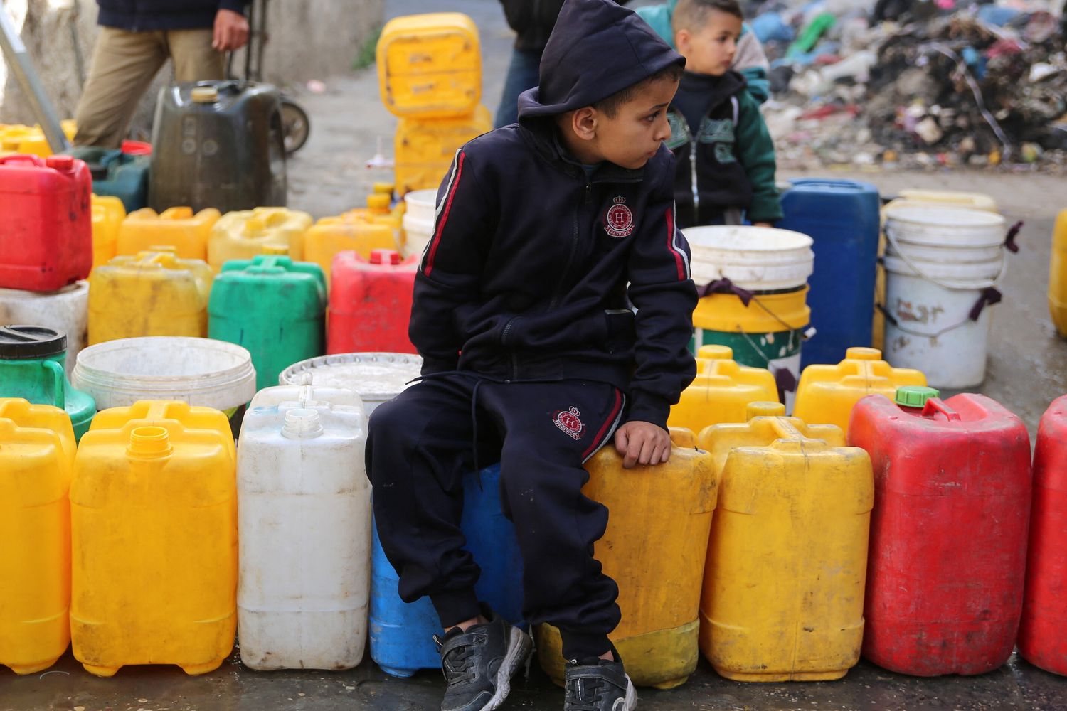Bambini palestinesi raccolgono acqua nel quartiere di Zaytoun, a Gaza City, durante le battaglie in corso tra Israele e Hamas