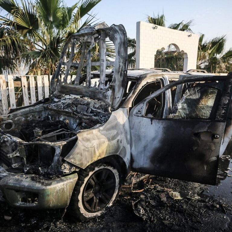 Palestinesi accanto a un veicolo a Deir Al-Balah, dove i dipendenti della World Central Kitchen (WCK) sono stati uccisi in un attacco aereo israeliano