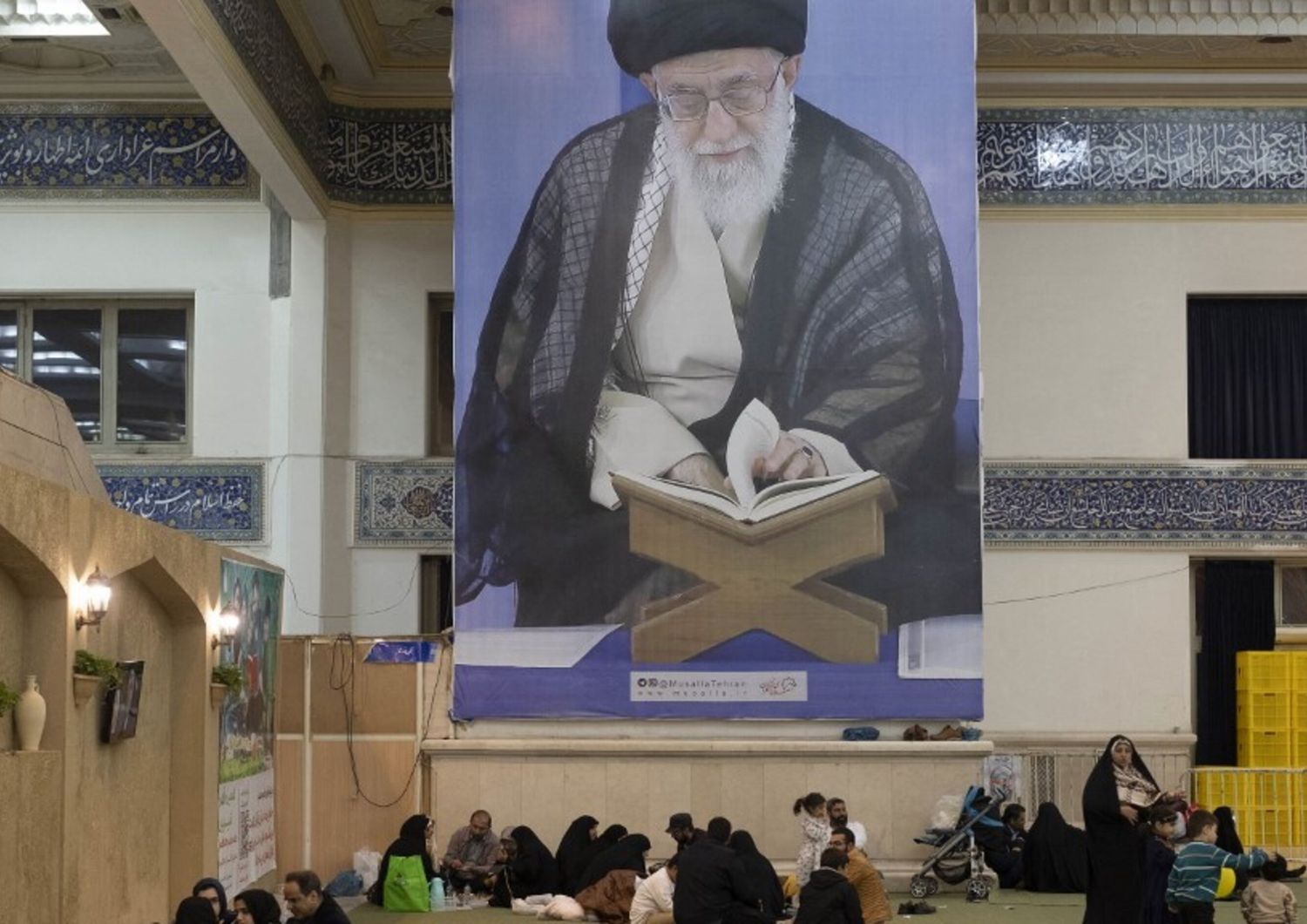 I fedeli iraniani riposano sotto un enorme ritratto della Guida Suprema dell'Iran, l'ayatollah Ali Khamenei, nella Grande Moschea dell'Imam Khomeini