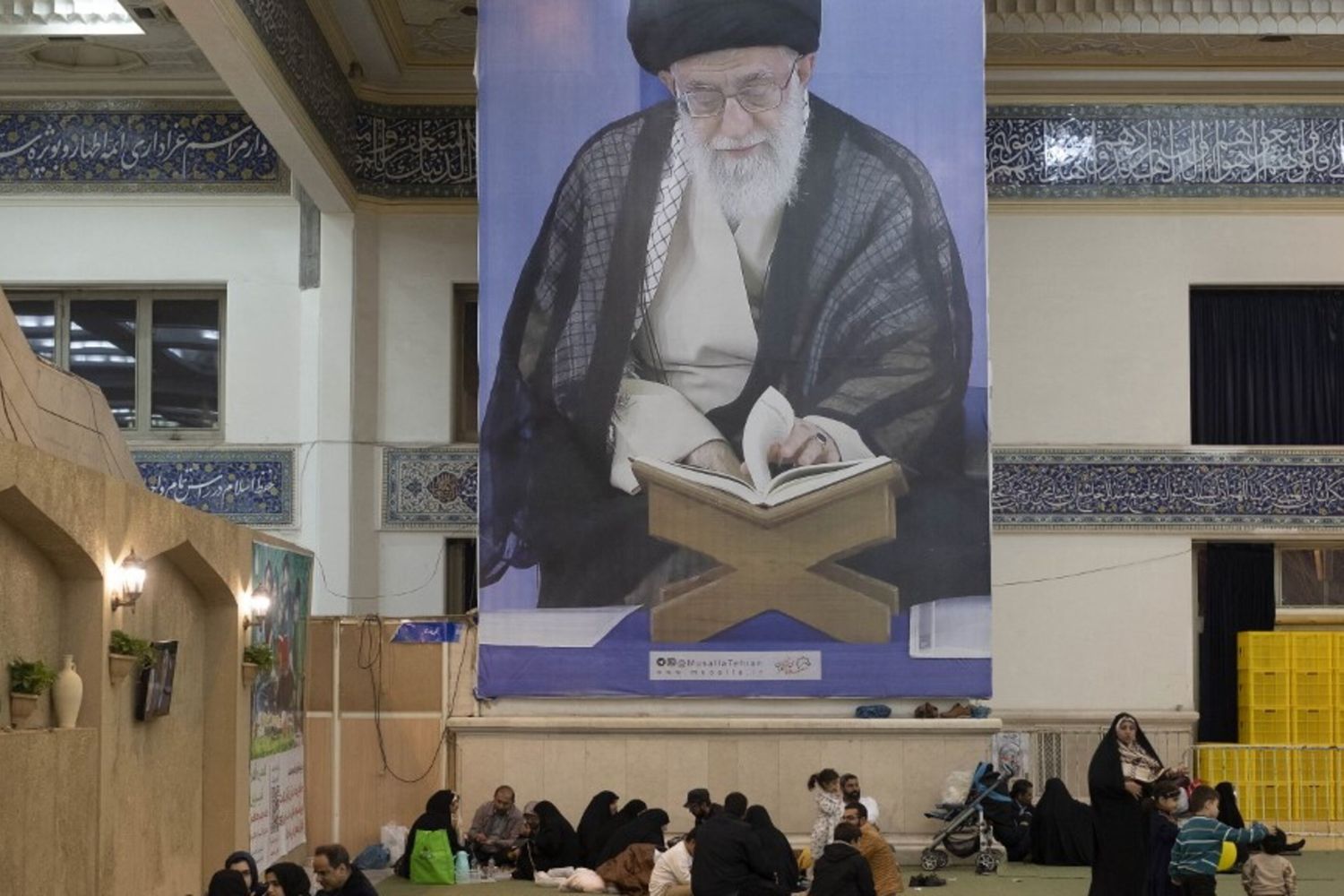 I fedeli iraniani riposano sotto un enorme ritratto della Guida Suprema dell'Iran, l'ayatollah Ali Khamenei, nella Grande Moschea dell'Imam Khomeini