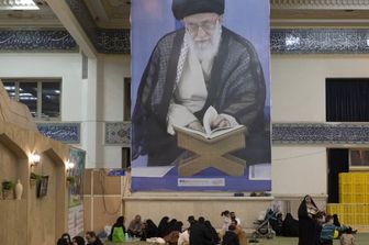 I fedeli iraniani riposano sotto un enorme ritratto della Guida Suprema dell'Iran, l'ayatollah Ali Khamenei, nella Grande Moschea dell'Imam Khomeini