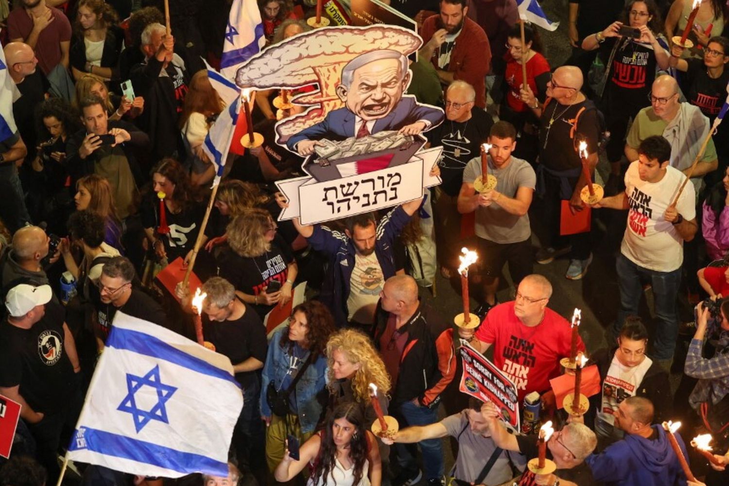 Familiari degli ostaggi israeliani esibiscono cartelli, sventolano bandiere e tengono una caricatura del premier Netanyahu
