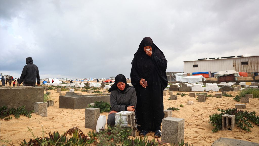 Due donne palestinesi piangono i loro cari in un cimitero di Rafah nel primo giorno di Eid Al-Fitr
