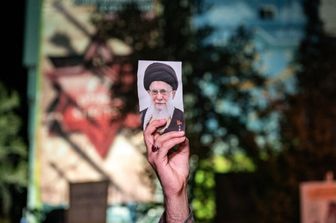 Un sostenitore filogovernativo iraniano mostra una foto del leader supremo iraniano Ali Khamenei in Piazza Palestina a Teheran, il 14 aprile 2024