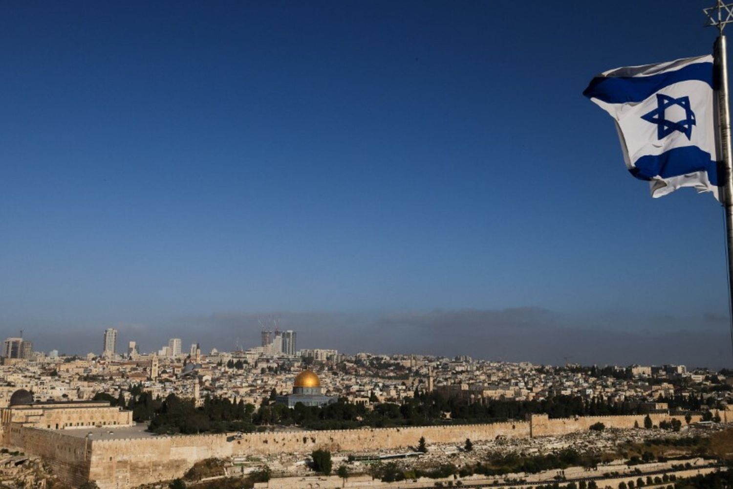 Una bandiera israeliana sventola sul Monte degli Ulivi che domina il complesso della moschea di Al Aqsa e lo skyline della città di Gerusalemme il 19 aprile 2024