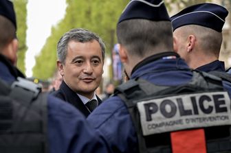 Il ministro francese dell'Interno Darmanin saluta gli agenti di polizia al suo arrivo per partecipare alla cerimonia di omaggio al defunto poliziotto Xavier Jugele, sul viale degli Champs-Elysees a Parigi il 19 aprile 2024