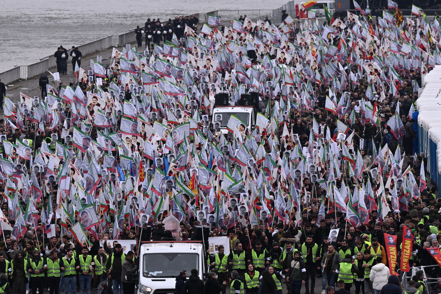 Sostenitori della comunità curda manifestano con bandiere e striscioni in occasione del 25° anniversario dell'arresto del leader del Partito dei Lavoratori del Kurdistan (PKK) Abdullah Ocalan sulle rive del fiume Reno a Colonia il 17 febbraio 2024