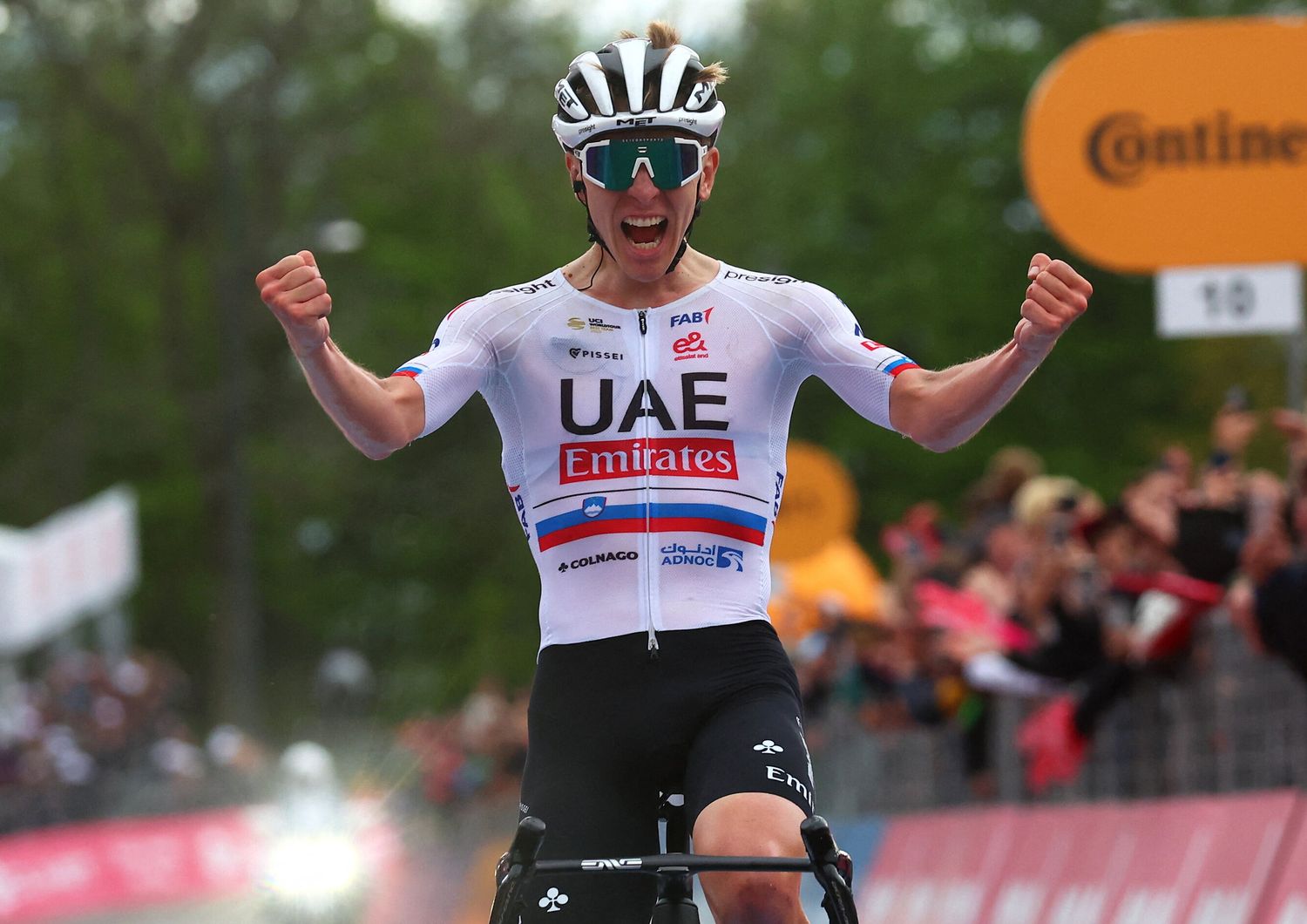 Tadej Pogacar del Team UAE festeggia mentre taglia il traguardo della 2ª tappa del 107° Giro d'Italia di ciclismo, 161 km tra San Francesco al Campo e il Santuario di Oropa (Biella), il 5 maggio 2024 a Biella