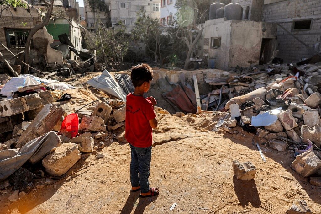 Bambino passeggia tra le rovine di Rafah