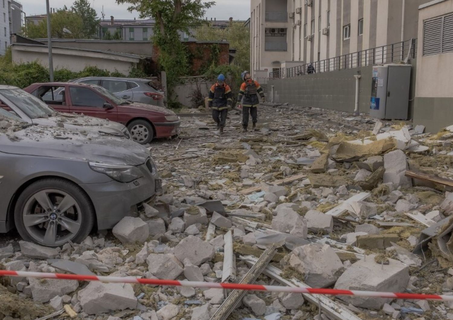 I soccorritori camminano tra le macerie davanti a un edificio residenziale danneggiato a seguito di un attacco missilistico a Kharkiv