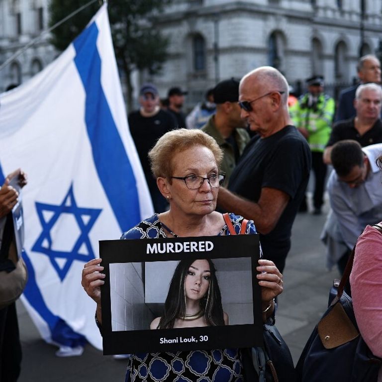 Una donna mostra la foto di Shani Louk