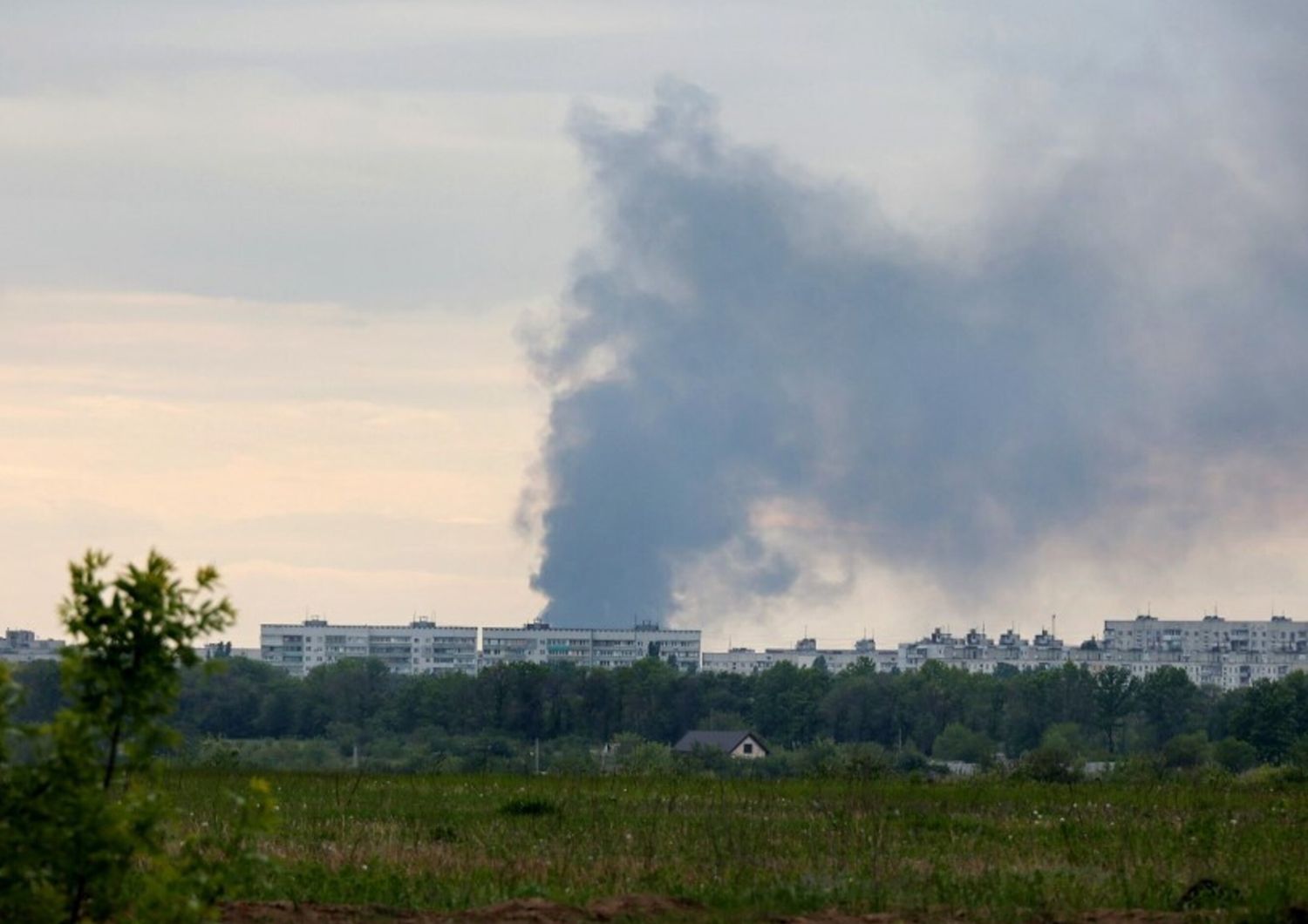 Una colonna di fumo si leva da dietro i condomini dopo il bombardamento delle truppe russe a Kharkiv