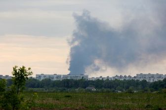 Una colonna di fumo si leva da dietro i condomini dopo il bombardamento delle truppe russe a Kharkiv