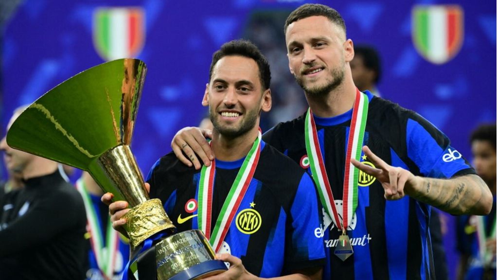 Hakan Calhanoglu e Marko Arnautovic posano con il trofeo