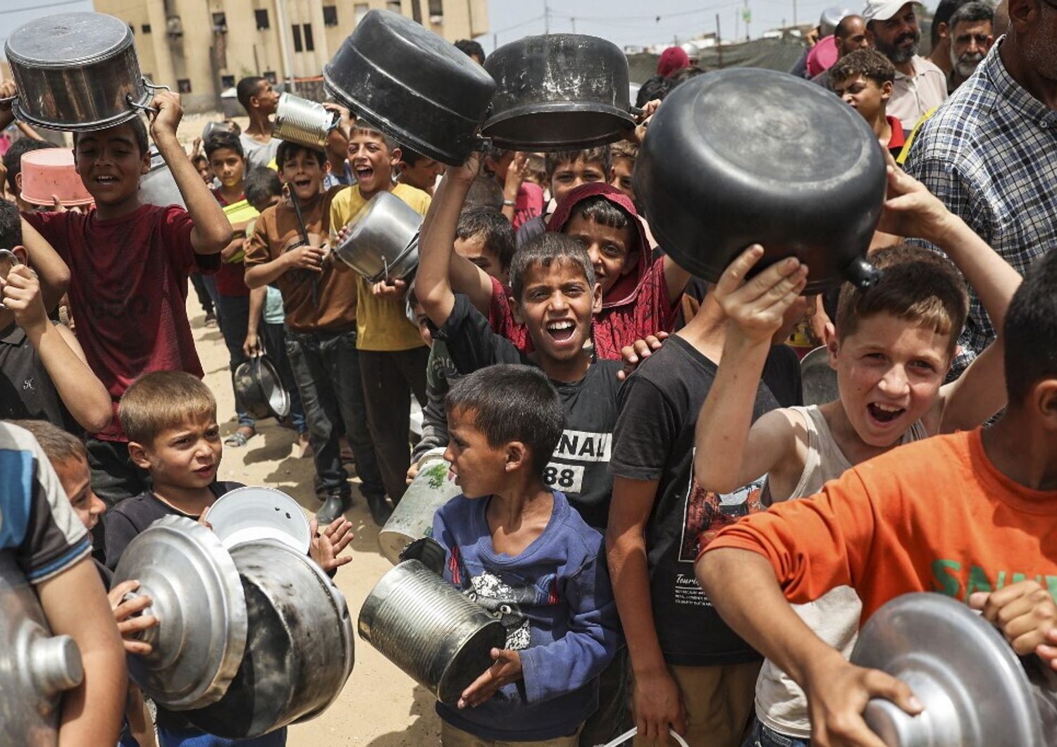 Rifugiati palestinesi in fila per ricevere aiuti arrivati tramite il valico di Rafah