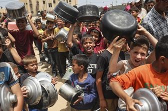 Rifugiati palestinesi in fila per ricevere aiuti arrivati tramite il valico di Rafah