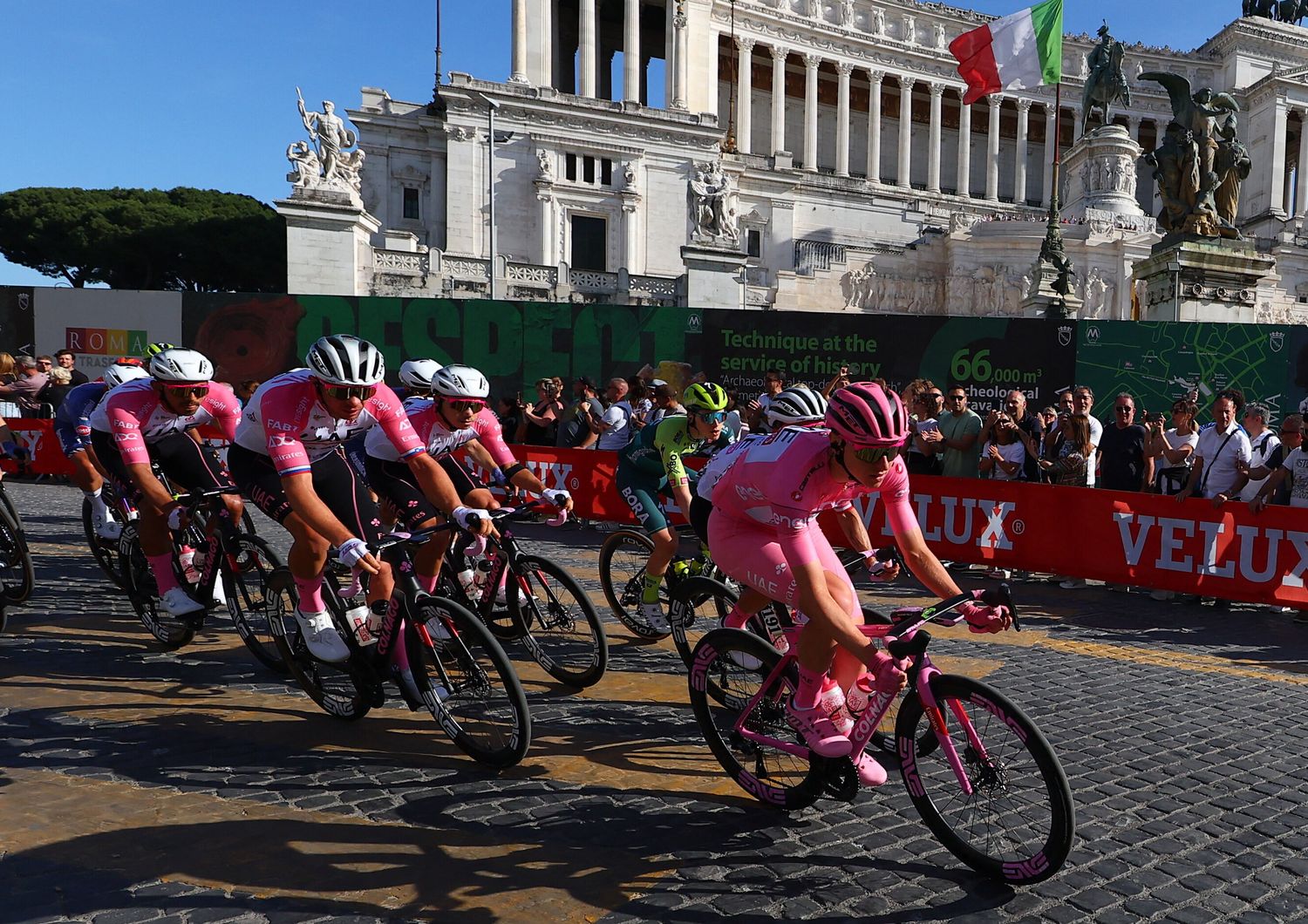 Il corridore sloveno del Team UAE Tadej Pogacar con la maglia rosa di leader della classifica pedala con il gruppo davanti all'Altare della Patria in Piazza Venezia