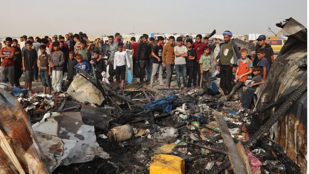 Palestinesi si riuniscono sul luogo di un attacco israeliano a un campo per sfollati interni a Rafah