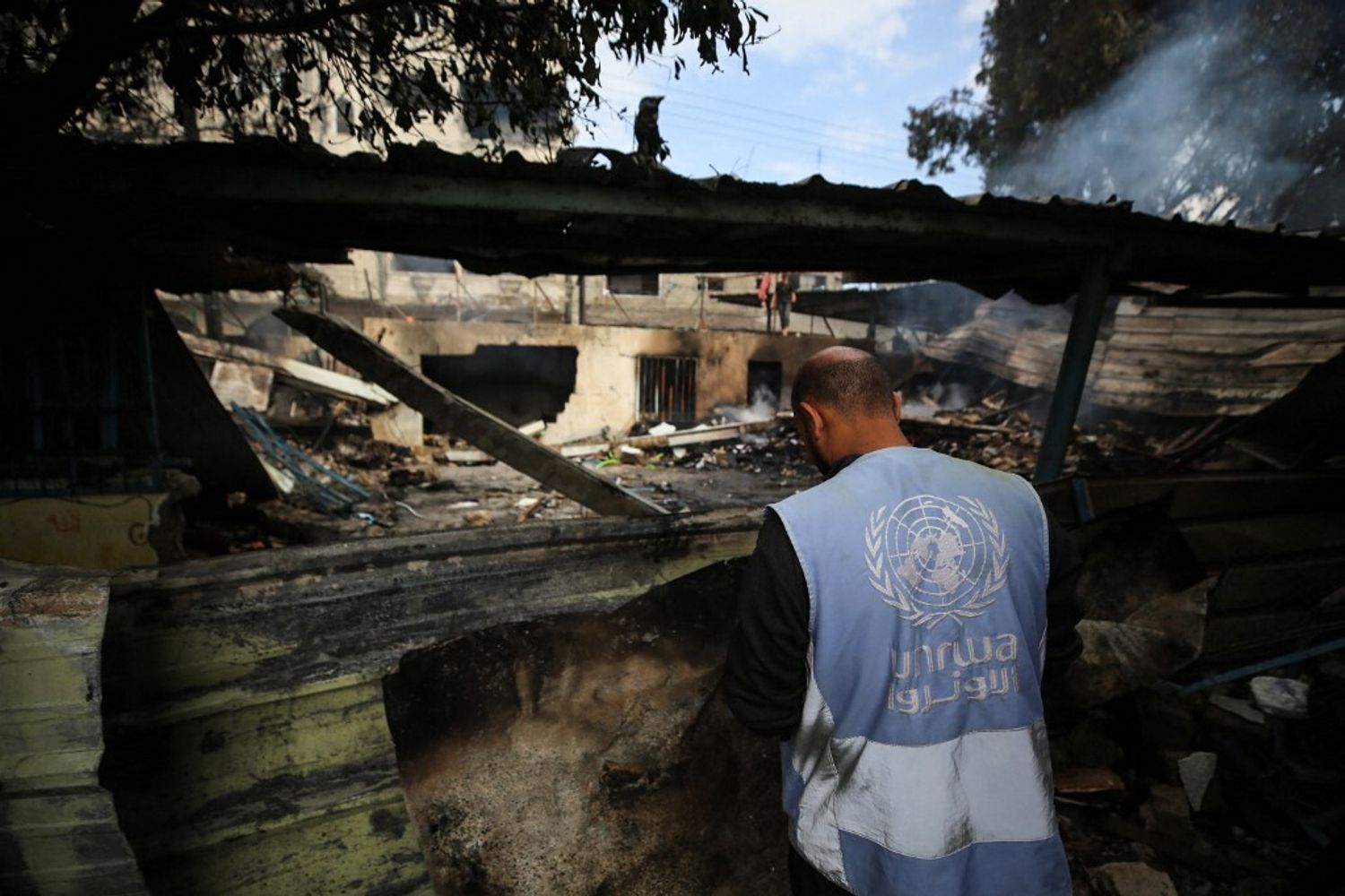 Un dipendente dell’Unrwa davanti alle macerie di Gaza