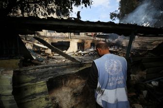 Un dipendente dell’Unrwa davanti alle macerie di Gaza