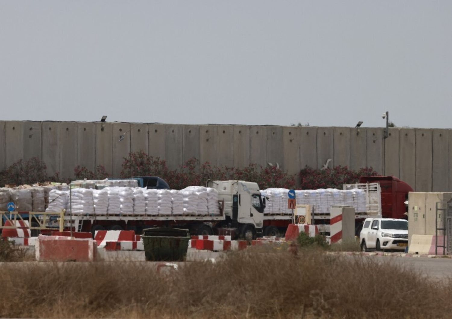 Camion che trasportano aiuti umanitari attendono sul lato israeliano del valico di frontiera di Kerem Shalom con la Striscia di Gaza, nel sud di Israele