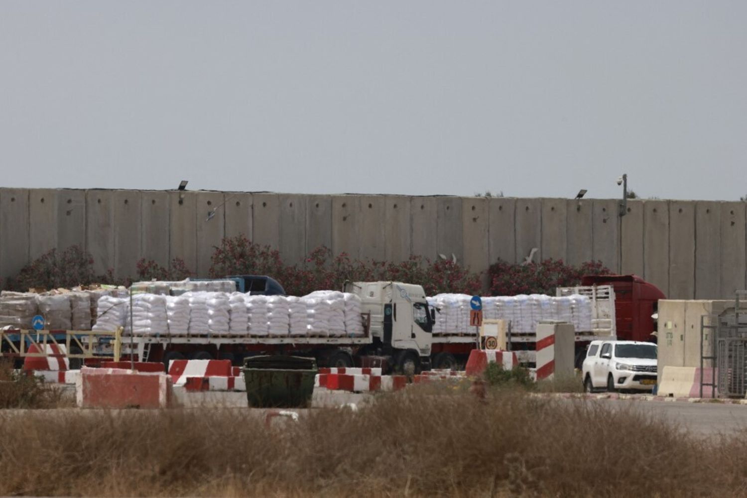 Camion che trasportano aiuti umanitari attendono sul lato israeliano del valico di frontiera di Kerem Shalom con la Striscia di Gaza, nel sud di Israele