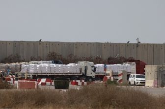 Camion che trasportano aiuti umanitari attendono sul lato israeliano del valico di frontiera di Kerem Shalom con la Striscia di Gaza, nel sud di Israele