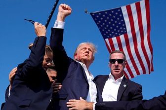 La foto iconica dell'AP dopo l'attentato di Trump insanguinato e con il pugno alzato con alle spalle la bandiera Usa