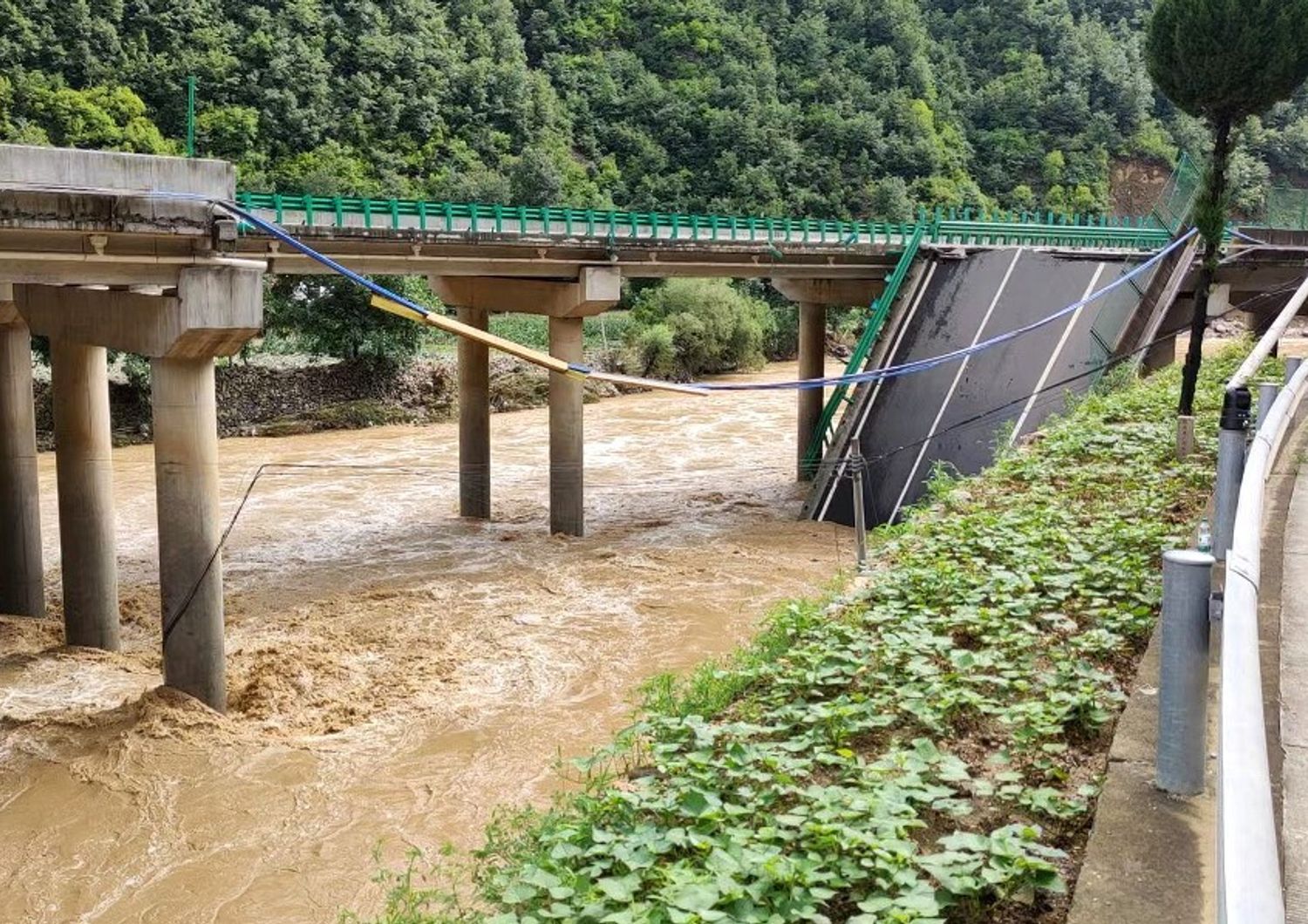 cina crolla ponte dopo piogge torrenziali morti dispersi