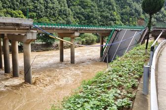 cina crolla ponte dopo piogge torrenziali morti dispersi