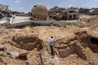 Un palestinese ispeziona un'area scavata dove l'esercito israeliano avrebbe condotto operazioni prima di ritirarsi nella città di Bani Suhayla, nel sud della Striscia di Gaza