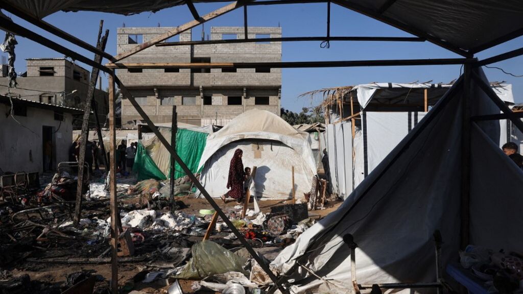 Una donna cammina dopo un attacco israeliano della notte che ha colpito le tende usate come rifugi temporanei dai palestinesi sfollati nel cortile dell'ospedale Al-Aqsa Martyrs a Deir el-Balah, nella Striscia di Gaza centrale, il 4 agosto 2024