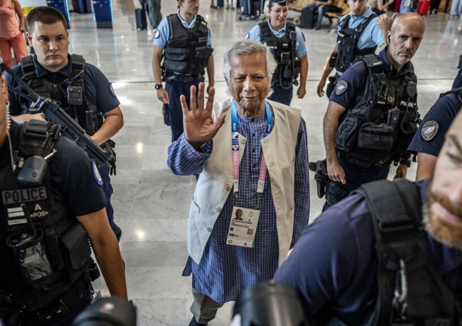 Muhammad Yunus scortato dal personale della polizia francese all'arrivo all'aeroporto di Roissy-Charles de Gaulle, prima di partire per il Bangladesh