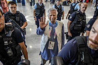 Muhammad Yunus scortato dal personale della polizia francese all'arrivo all'aeroporto di Roissy-Charles de Gaulle, prima di partire per il Bangladesh