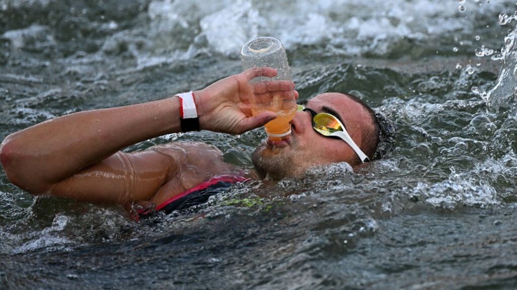 Domenico Acerenza beve nella Senna durante la finale della maratona di nuoto maschile ai Giochi Olimpici di Parigi 2024 a Pont Alexandre III