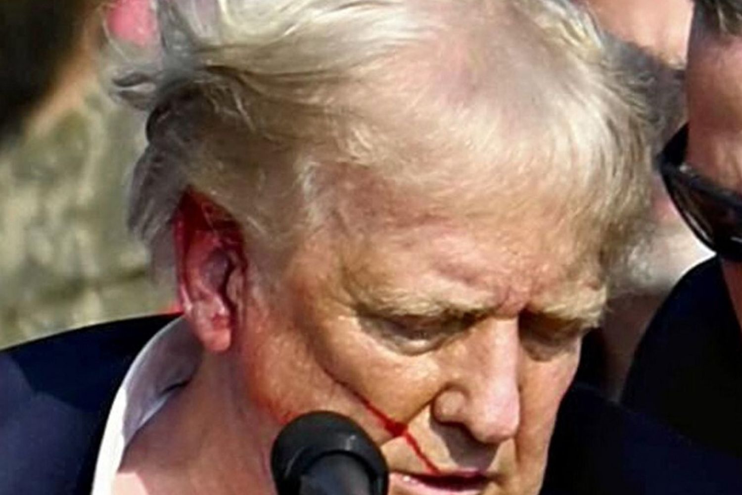 Trump pochi istanti dopo essere colpito dal proiettile