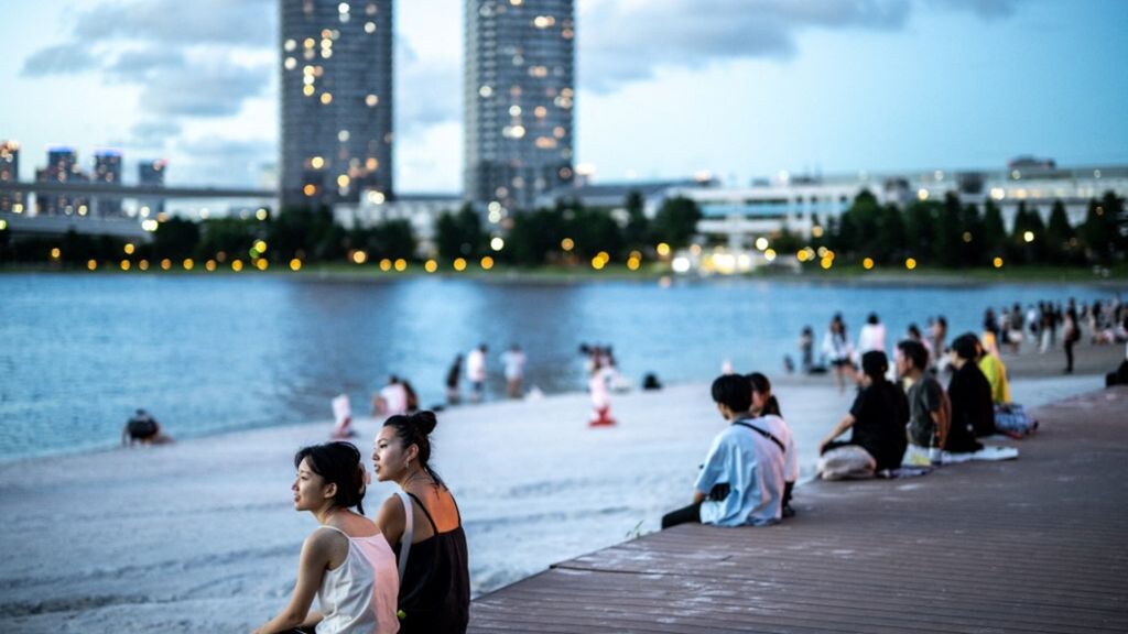 Des filles attendent à Odaiba (Tokyo) l'arrivé du navire-école italien Amerigo Vespucci