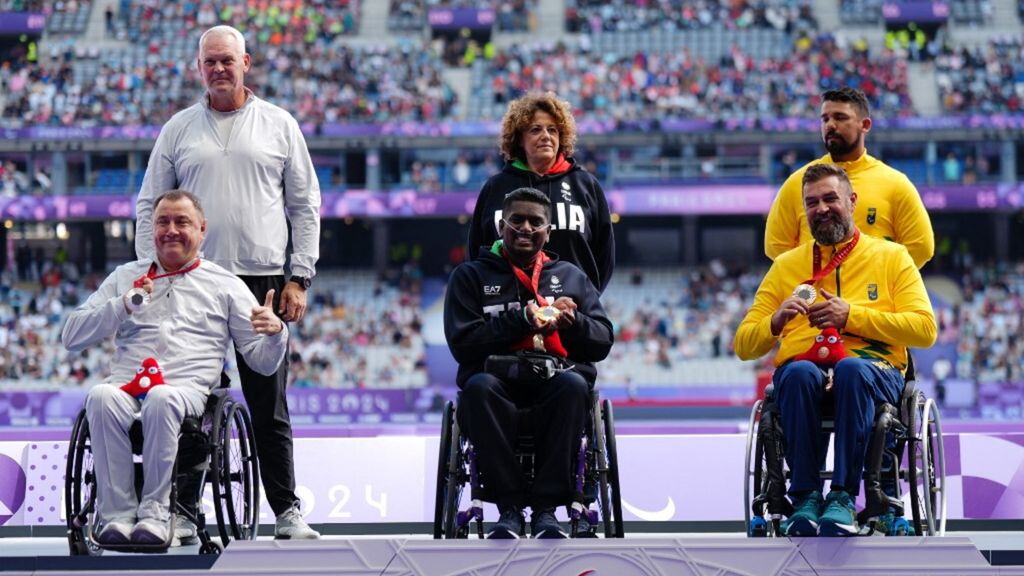 La medaglia d'argento Aigars Apinis, la medaglia d'oro italiana Rigivan Ganeshamoorthy e la medaglia di bronzo Andre Rocha nella finale del lancio del disco F52 alle Paralimpiadi di Parigi 2024